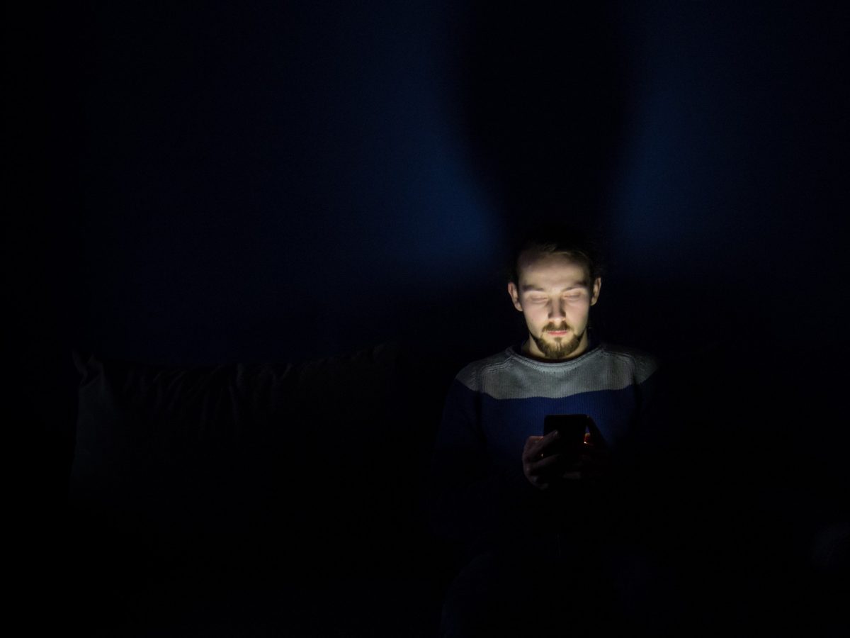 Man viewing phone is dark